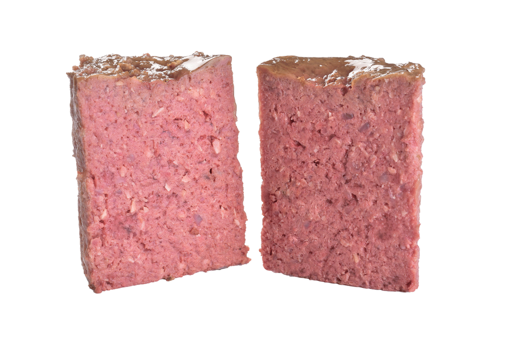 Brit Premium Adult Wet Dog Food with Chicken & Hearts loaf cut in half  on a white background