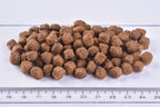 Brit Premium Dog Dry Food Adult Small Kibble on a white surface with a ruler for scale.