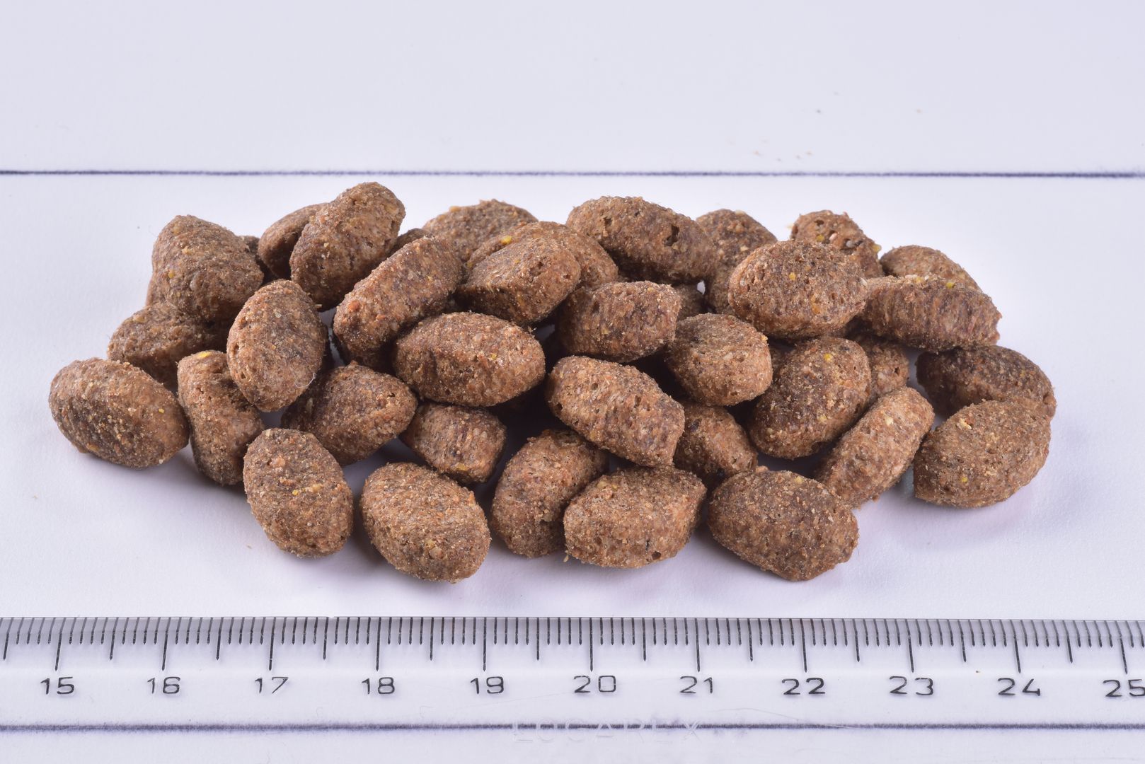 Dog food pelletsBrit Premium Dog Dry Food Light Turkey and Oat Kibble next to a ruler for scale.