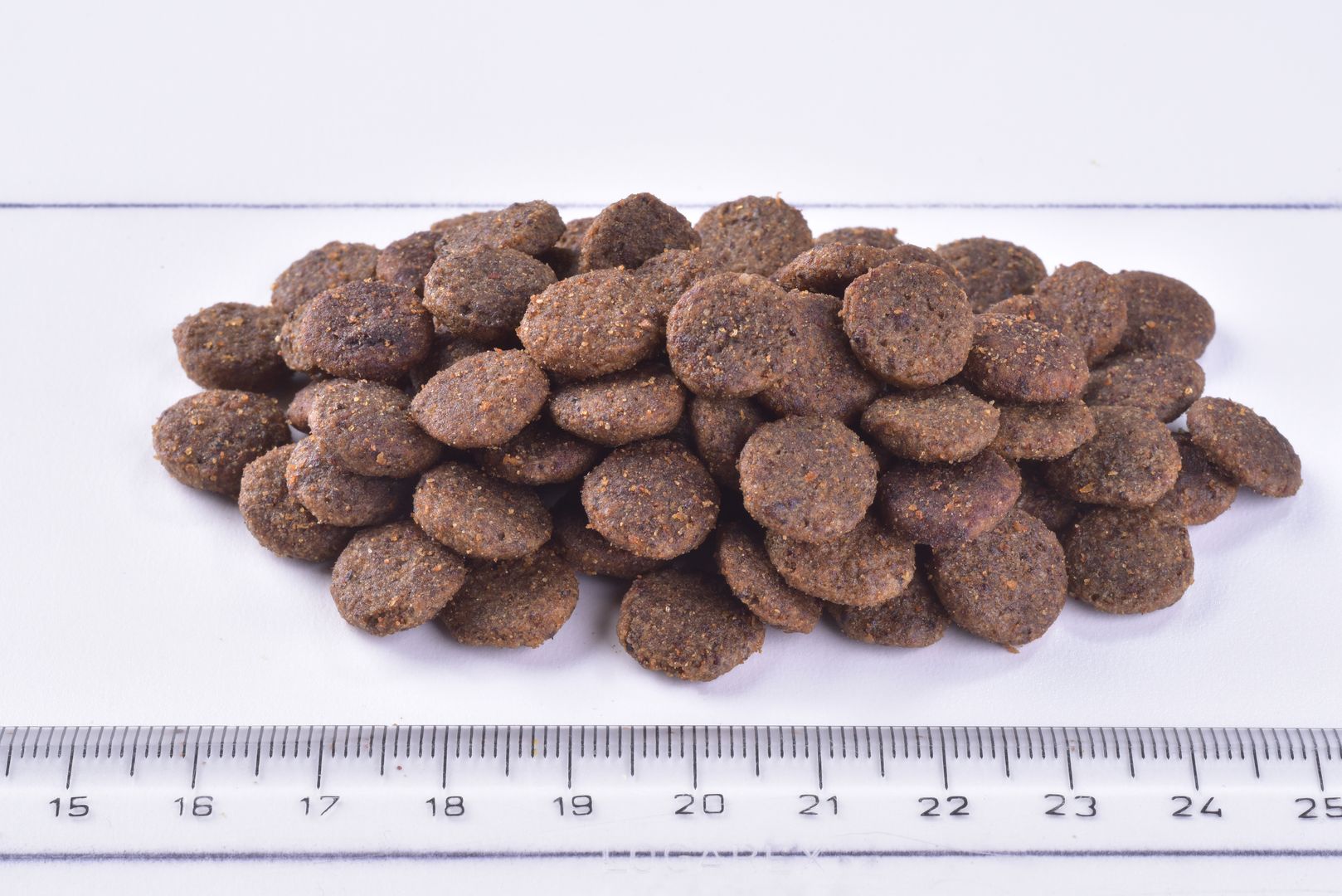 Brit Premium Sterilised Adult Cat Dry Food - Chicken group of kibble  with a ruler for scale on a white background