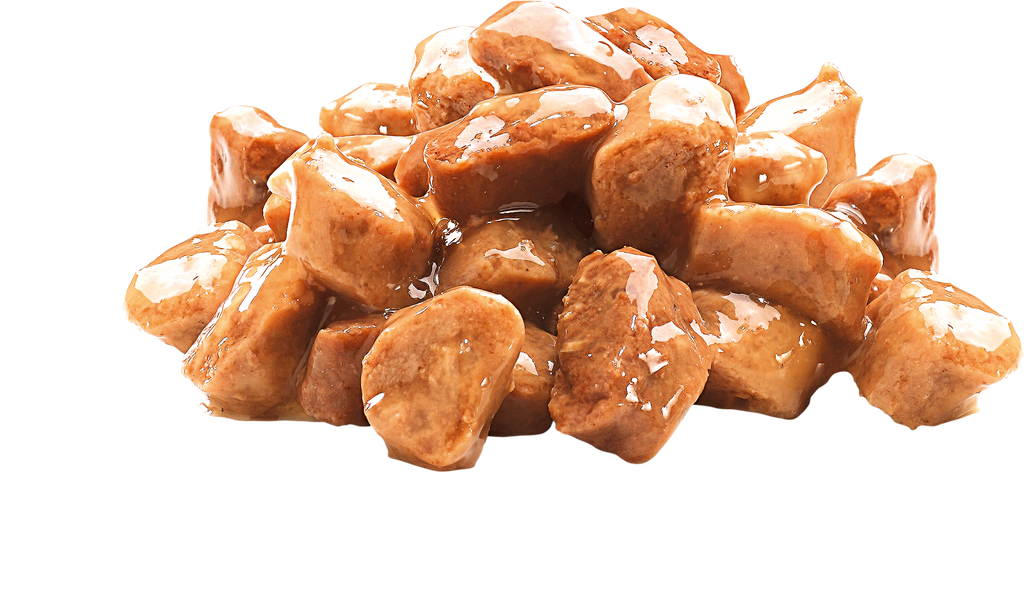 Chunks of Brit Premium Kitten Chicken in Gravy Wet Cat Food pieces on a white background